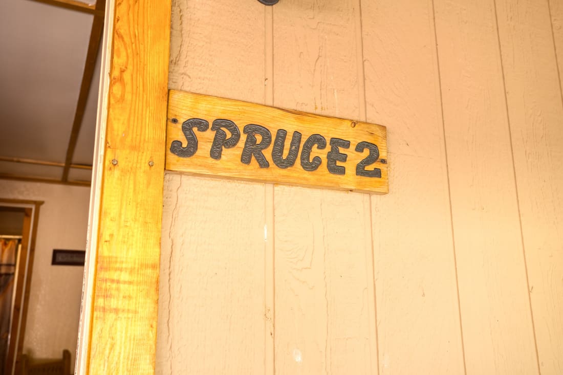 The hand-painted Spruce 2 sign on the cottage door