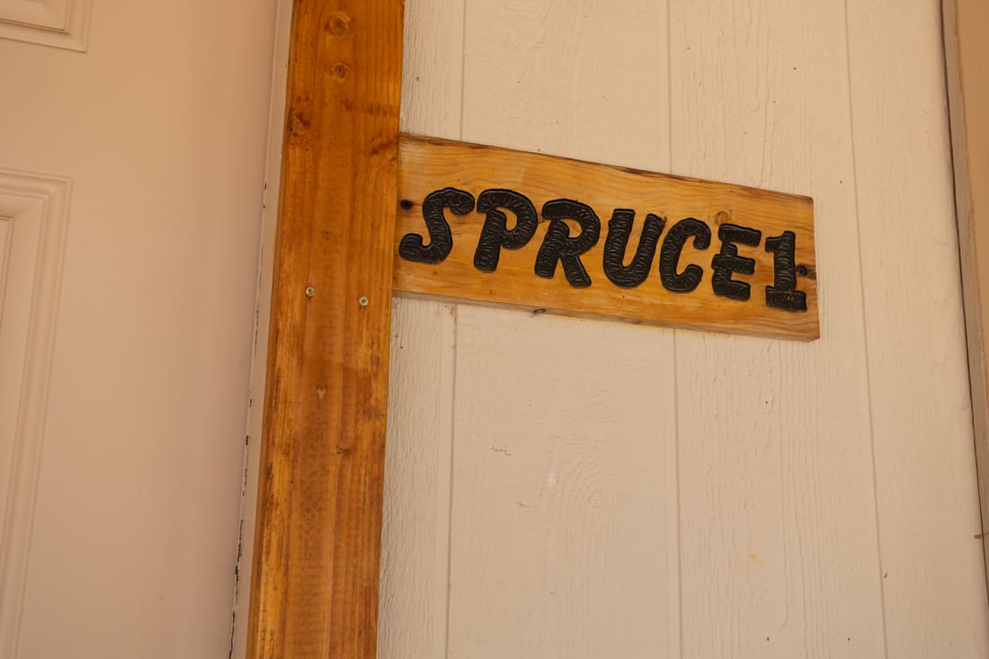 The hand-painted Spruce 1 sign on the cottage door