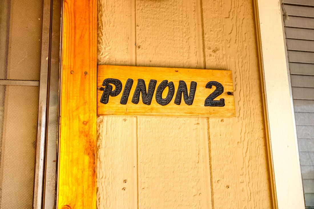 The hand-painted Pinon 2 sign on the cottage door