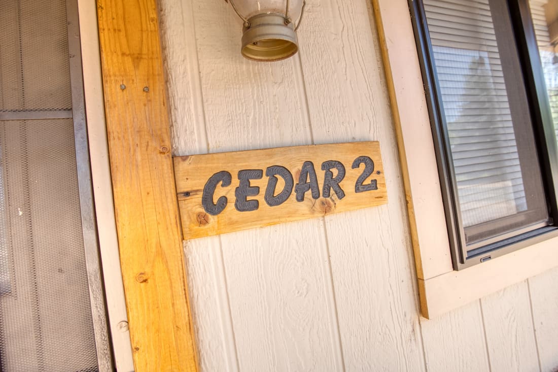 The hand-painted Cedar 2 sign on the cottage door